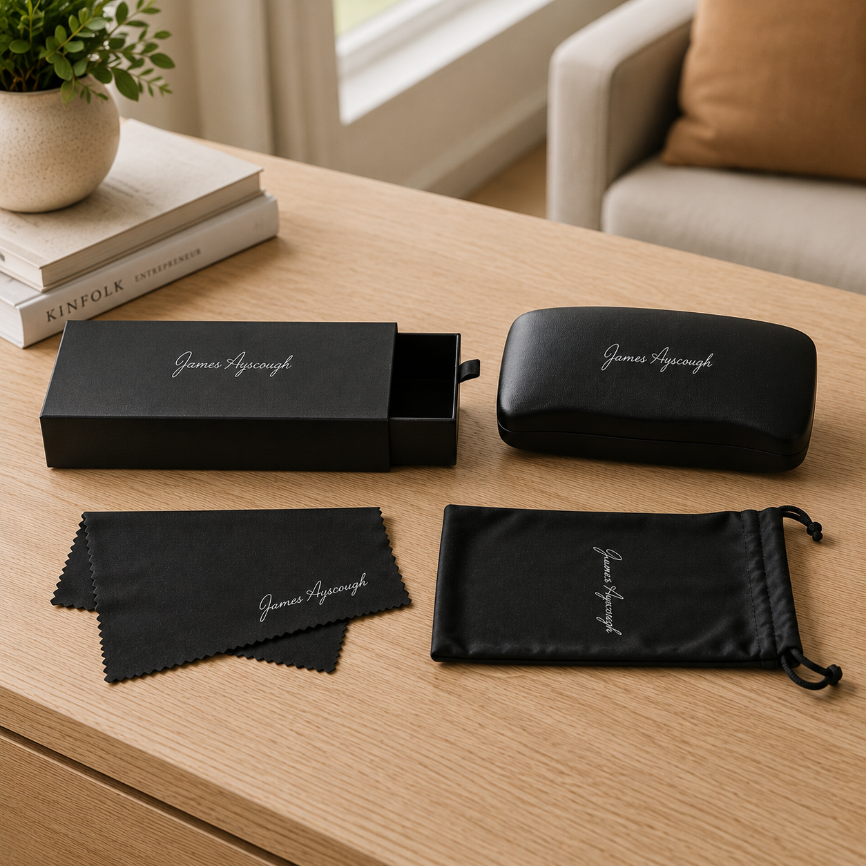 Eyewear accessories set on a wooden table with 'James Ayscough' branding.